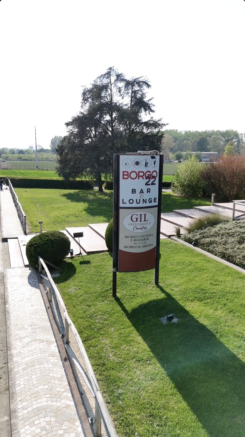 Insegna esterna di Borgo 22 Bar e Lounge lungo il viale d'ingresso nel giardino